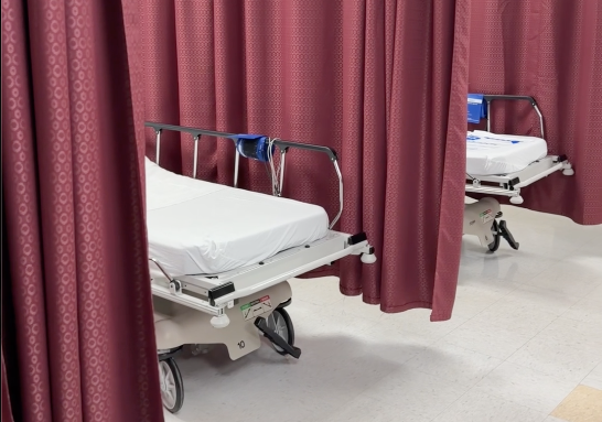 Healthcare privacy curtains and patient beds in a clinical care environment.